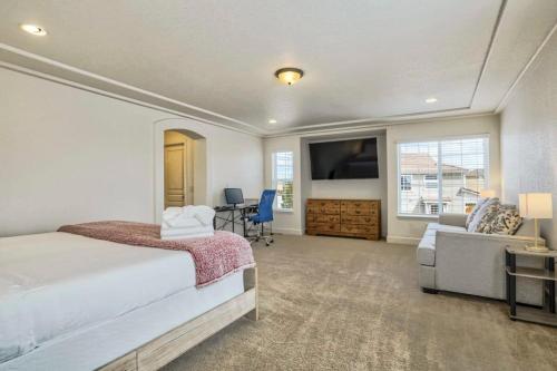 a bedroom with a bed and a tv and a couch at 4BR Hot Tub Pool Table, Ping Pong, Foosball! in Peyton