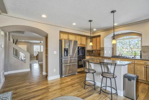 a large kitchen with a counter and a refrigerator at 4BR Hot Tub Pool Table, Ping Pong, Foosball! in Peyton
