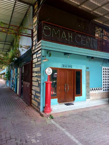 a red fire hydrant in front of a building at Hotel Omah Cepit in Cepit