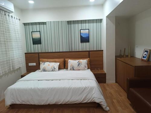a bedroom with a large bed with a wooden headboard at Hotel Green Park - Sector 11 in Gandhinagar