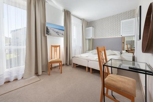 a bedroom with a bed and a table and chairs at Wojciech-pokoje PREMIUM-śniadania bufet-2 sale zabaw-możliwość wyżywienia in Władysławowo