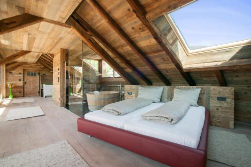 a large bed in a room with a skylight at Neuprantl Apartments in Lana