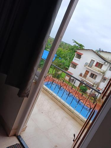 a view of a pool from a window at Ronne's Little Baga service apartments in Goa