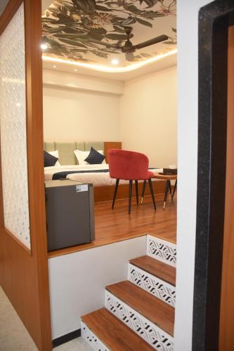 a room with a bed and a red chair at Hotel Pride Of Chittor in Chittaurgarh