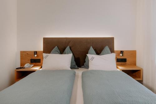 a bedroom with two beds with blue and white pillows at Garni-Hotel Farmerhof in Parcines