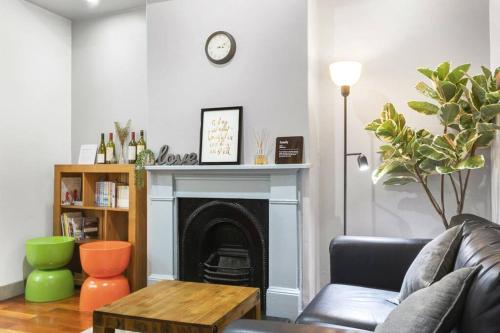 a living room with a couch and a fireplace at Stylish 2 Story Terrace House in Chippendale in Sydney