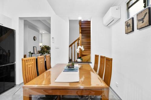 a dining room with a wooden table and chairs at Stylish 2 Story Terrace House in Chippendale in Sydney