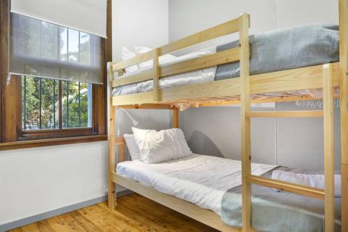 a bedroom with two bunk beds and a window at Stylish 2 Story Terrace House in Chippendale in Sydney
