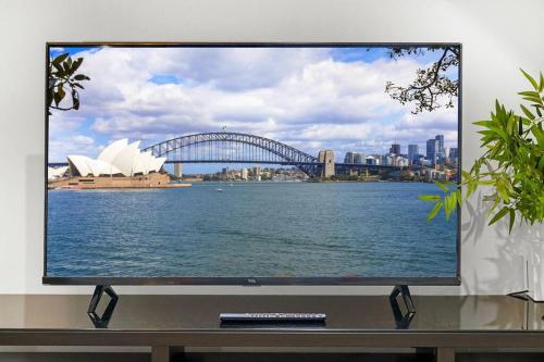 a flat screen tv sitting on a table with a view of a sydney at Stylish 2 Story Terrace House in Chippendale in Sydney