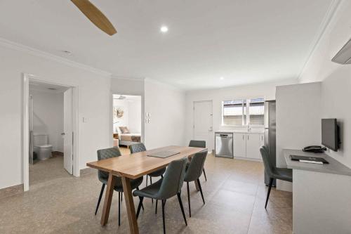 a kitchen and dining room with a table and chairs at Moonlight Bay Suites in Broome
