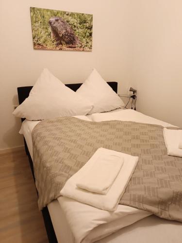 a bed with white sheets and pillows on it at Haus Obermaiselstein in Obermaiselstein