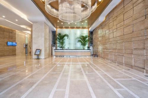 a large lobby with a chandelier and a building at Pearl River International Hotel - Canmetro line 11 YiJing Lu station in Guangzhou