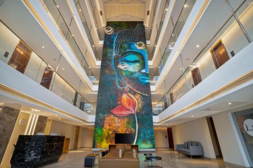 a large painting in the lobby of a building with aificantificantificantificantificant at De Mandarin Candolim Beach Goa in Candolim