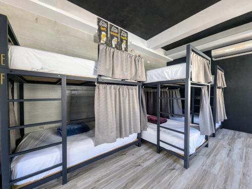 three bunk beds in a room with wooden floors at 40Inn Backpackers Warehouse in Taitung City
