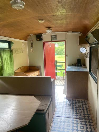 une vue intérieure d'une caravane avec une porte rouge dans l'établissement pipowagen Blagour midden in de natuur, à Lachapelle-Auzac