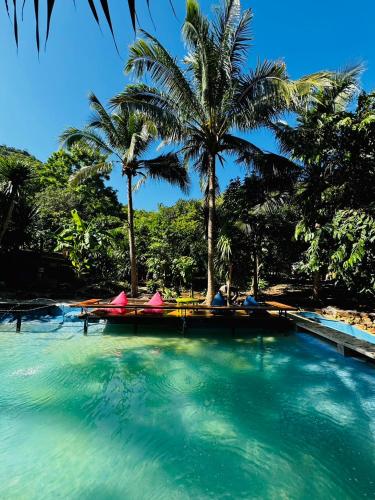 a swimming pool with palm trees in a resort at อิงภูเมาท์เท่นวิว เขาใหญ่ in Ban Khan Takhian