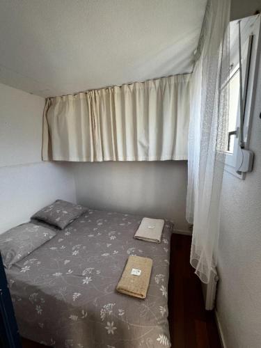 une petite chambre avec un lit et une fenêtre dans l'établissement Beach Side, à Lacanau-Océan