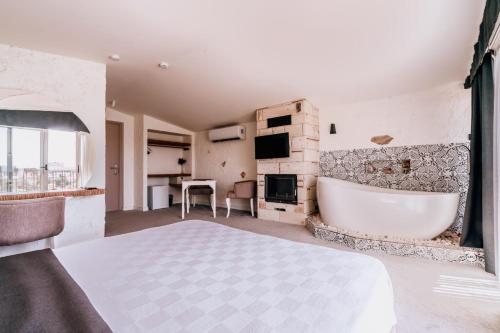 a bedroom with a large white tub in a room at Sirius Mİ Sun Paradise Hotel Çeşme in Çeşme
