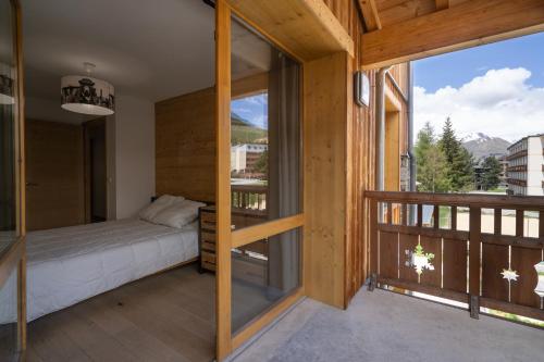 une chambre avec un lit et un balcon dans l'établissement Superbe appartement les 2 Alpes, à Les Deux Alpes