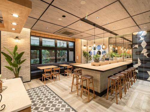 a restaurant with a large bar with stools at Super Hotel Premier Nagoya Sakuradoriguchi in Nagoya