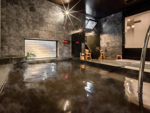 a pool of water in a room with lights at Super Hotel Premier Nagoya Sakuradoriguchi in Nagoya