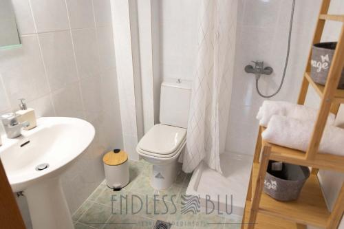 a bathroom with a toilet and a sink and a shower at Endless Blu Apartments in Pyrgadikia