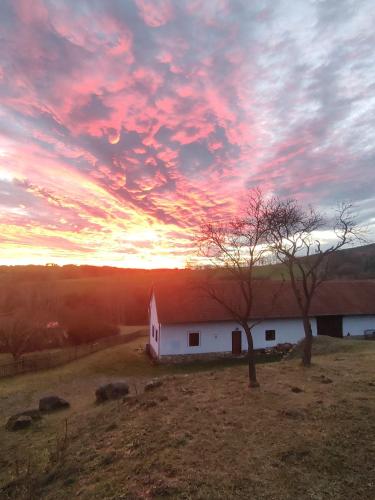 a barn in a field with a sunset in the sky at Country house - Slapy/Pazderny in Žďár