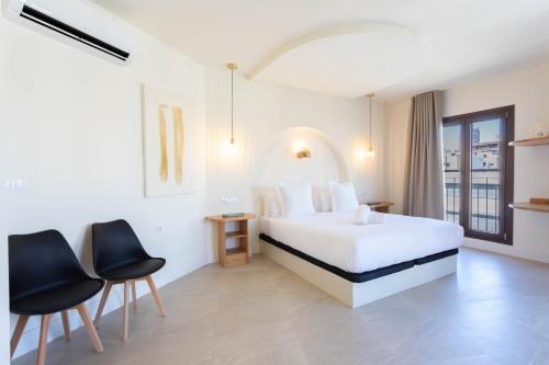 a hotel room with a bed and two chairs at Reina Victoria El Mercado in Alicante