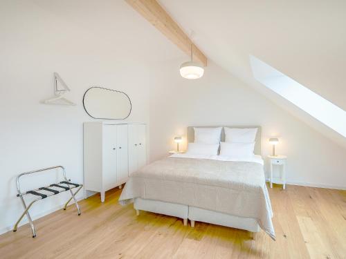 a white bedroom with a white bed and a mirror at FLAIR Homes - Design Apartments with Smart-TV, Self Check-in & Free Parking in Karlsruhe