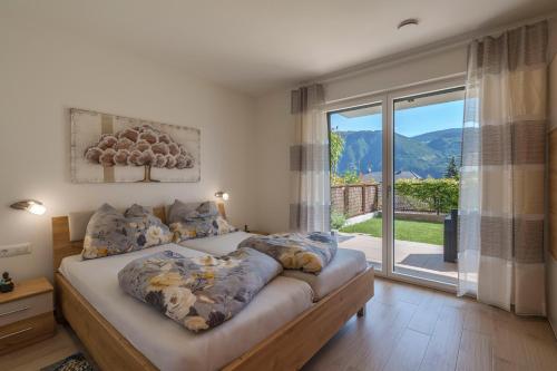 a bedroom with a bed with a large window at Residence Weinberg 8 in Nalles