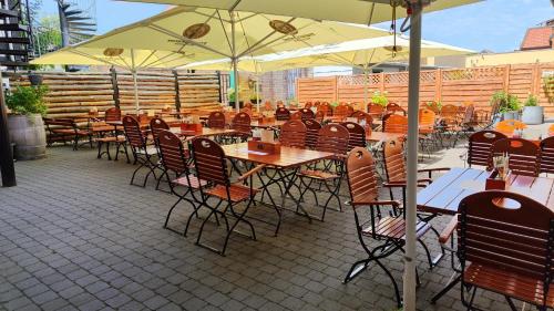 an outdoor restaurant with tables and chairs and umbrellas at Hotel Alte Brennerei in Wernigerode
