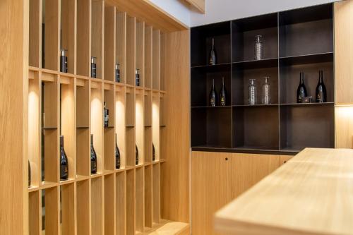 a wine cellar with wooden shelves with wine bottles at Eden Apartments in Siusi