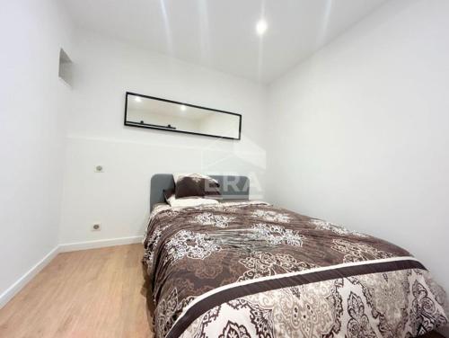 une chambre avec un lit et un miroir au mur dans l'établissement 2 pièces meublé neuf Pertuis, à Pertuis