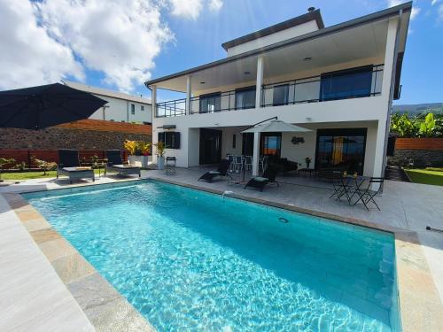 a swimming pool in front of a house at Villa JACARANDA - Les Émeraudes du Guillaume in Le Guillaume