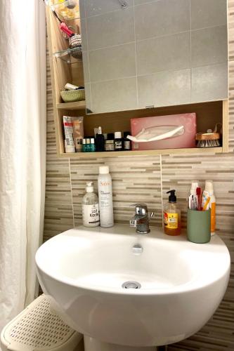 une salle de bain avec un lavabo blanc et un miroir dans l'établissement T3 Mer Calme Famille à Saint Aygulf, à Fréjus