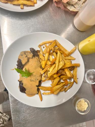 un piatto di cibo con patatine fritte su un tavolo di Biriyani House a Bobigny