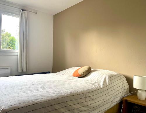 une chambre avec un lit avec un oreiller dessus dans l'établissement T3 Mer Calme Famille à Saint Aygulf, à Fréjus