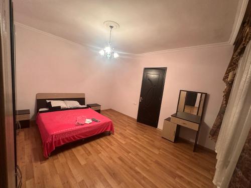 a bedroom with a red bed and a television at Ori Villa in Likani
