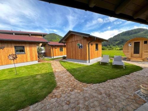 a patio with two chairs and a house at Meine kleine Auszeit - Die Schlafhütten in Sankt Georgen am Reith
