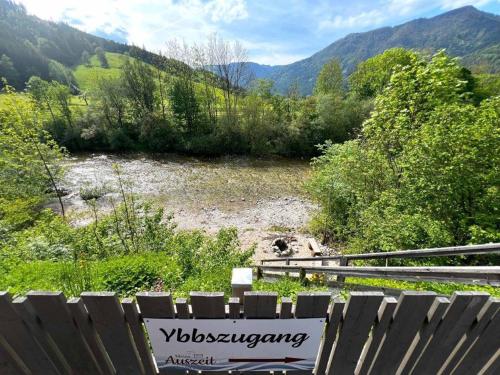 a sign on a fence in front of a river at Meine kleine Auszeit - Die Schlafhütten in Sankt Georgen am Reith