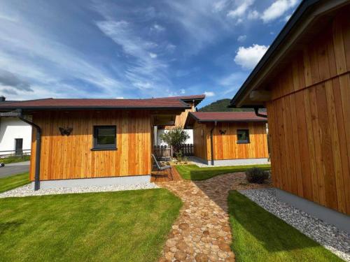 a house with wooden walls and green grass at Meine kleine Auszeit - Die Schlafhütten in Sankt Georgen am Reith