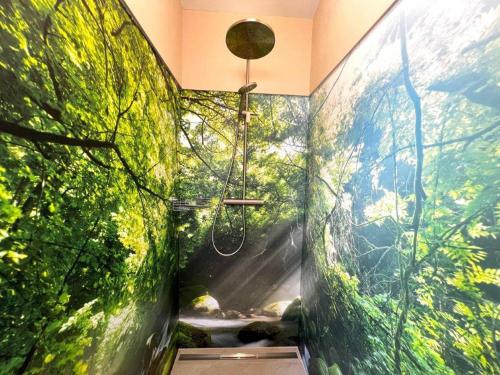 a bathroom with a shower with plants on the walls at Meine kleine Auszeit - Die Schlafhütten in Sankt Georgen am Reith