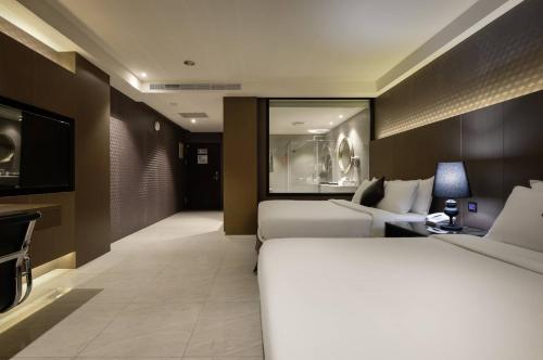 a hotel room with two beds and a television at M Hotel in Caotun