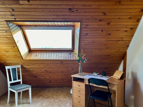an attic room with a desk and a window at Appartement une chambre plus une chambre bébé ou enfant trois ans à la campagne au calme in Cléguérec