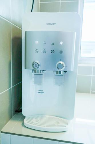 a white coffee machine sitting on a counter in a bathroom at Comfy Cafe 43 Homestay- Holiday Home in Tanah Rata