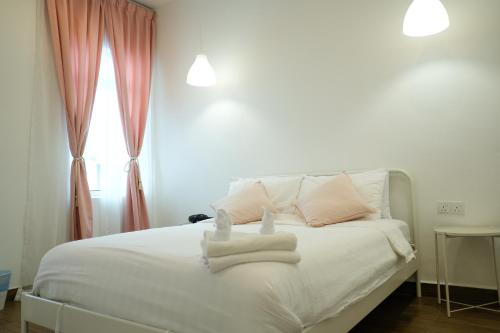 a bedroom with a white bed with towels on it at Comfy Cafe 43 Homestay- Holiday Home in Tanah Rata