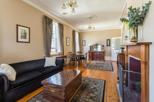 uma sala de estar com um sofá e uma mesa em Grand Old Duke em Hobart