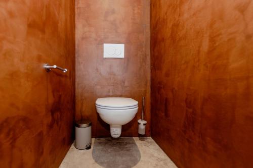 a bathroom with a toilet in a wooden wall at Zur Nandl in St. Wolfgang