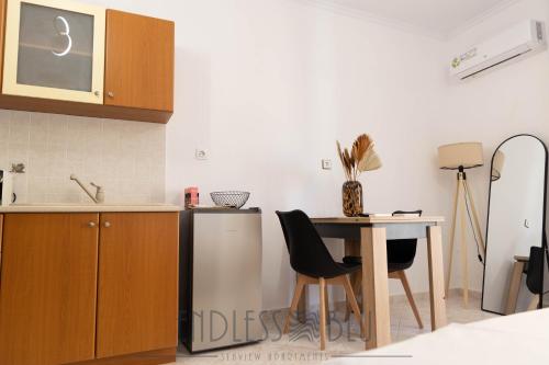a kitchen with a table and chairs and a counter at Endless Blu Apartments in Pyrgadikia