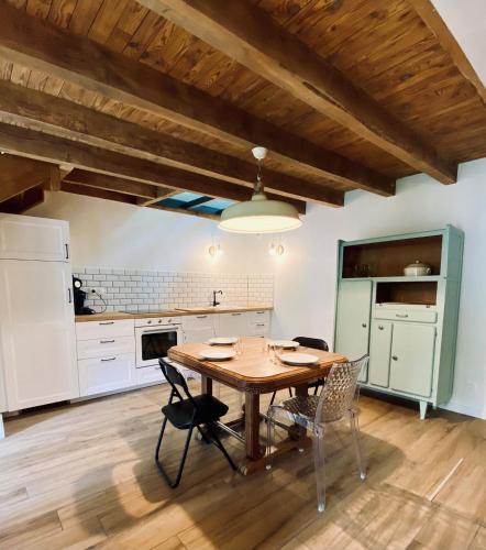 une cuisine avec une table et des chaises dans une pièce dans l'établissement La haut Maison a la campagne, à Mandailles